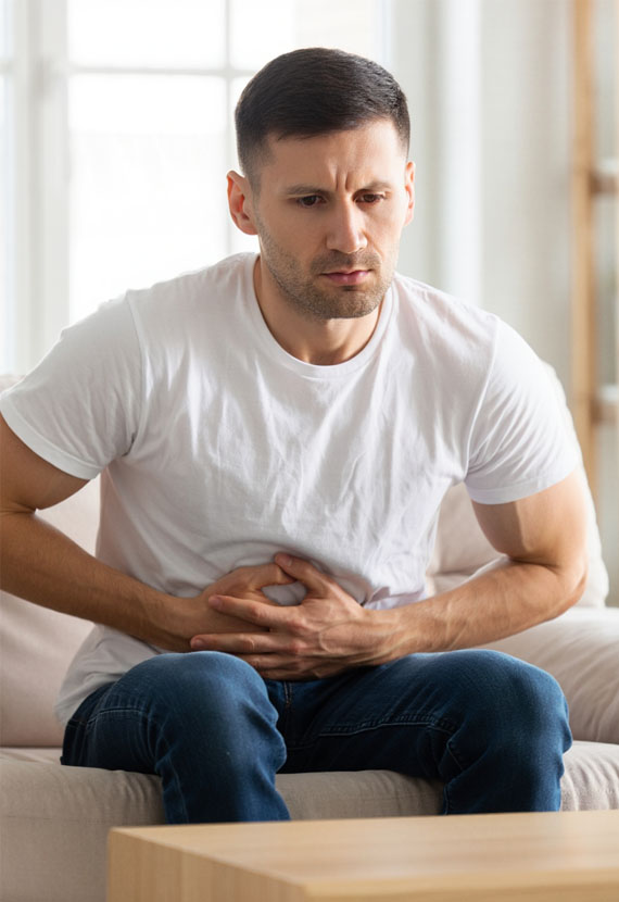 Мужчина держится двумя руками за живот